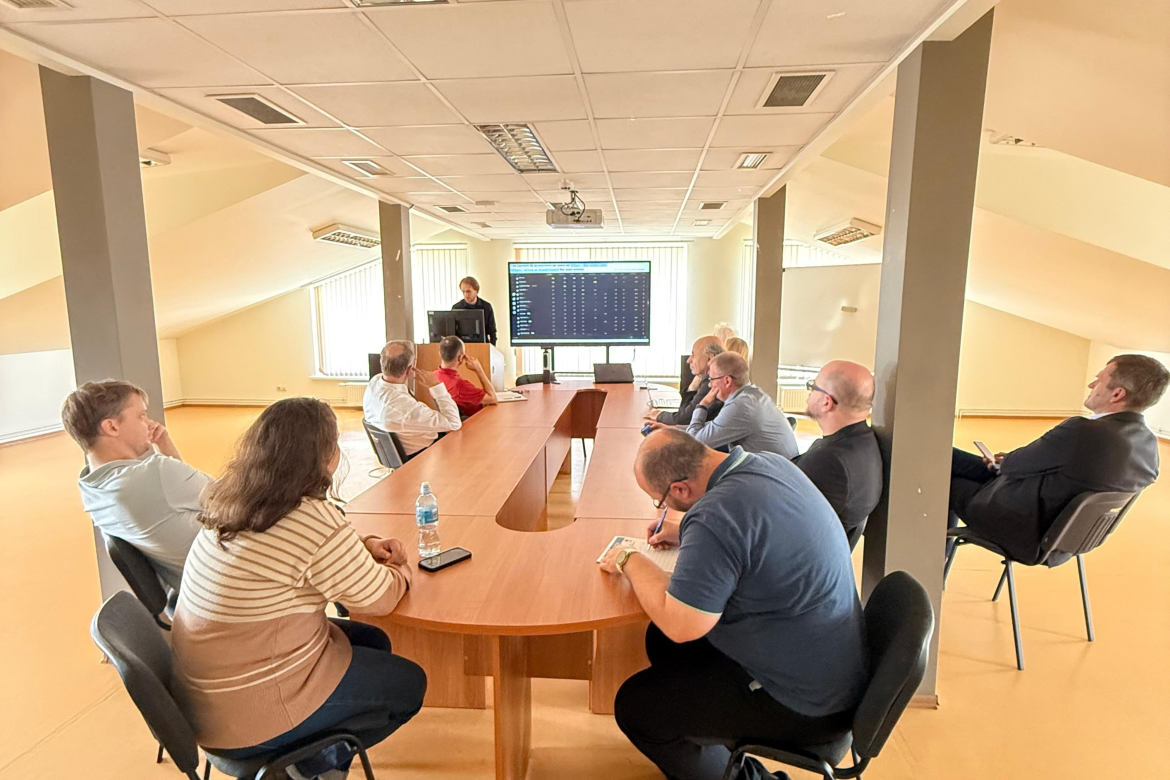 Cilvēki sēž pie galda, notiek darba seminārs