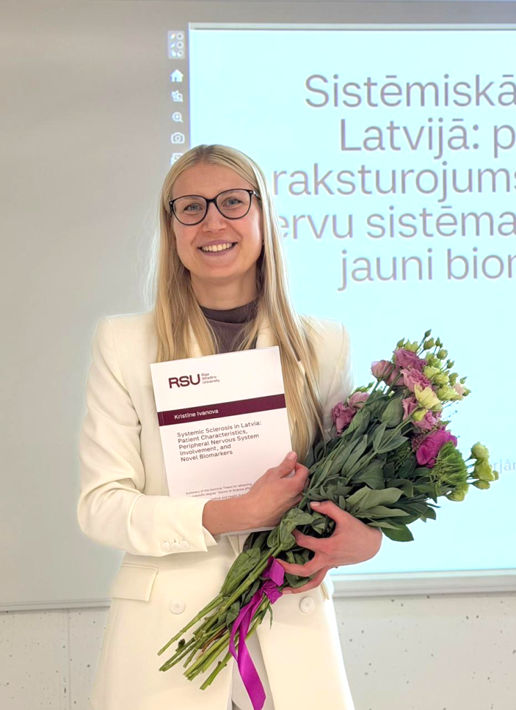 Pētniece Kristīne Ivanova ar ziediem pēc sava promocijas darba aizstāvēšanas
