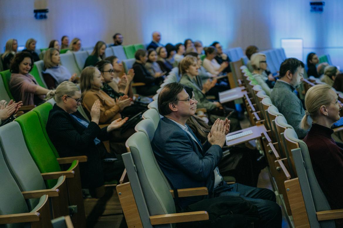 Pasākuma apmeklētāji sēž auditorijas krēslos