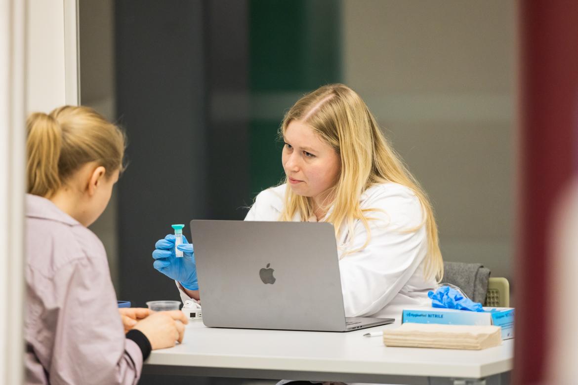 Mediķis ņem siekalu paraugu no pacientes